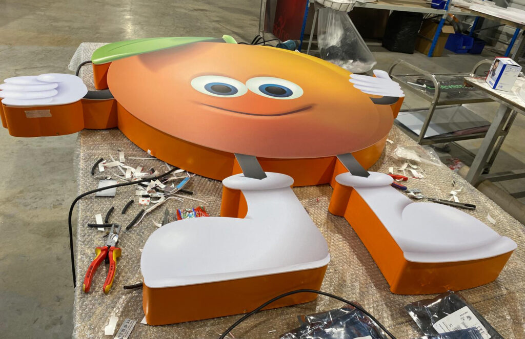 Logo lumineux à l'Atelier : montage de la face PMMA avec décor adhésif pelliculé